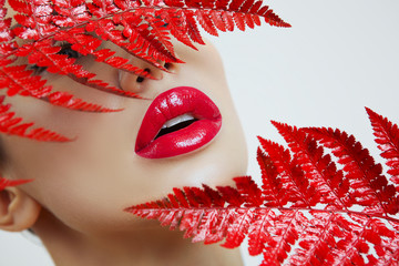 A woman with Sensual red lips and a fern