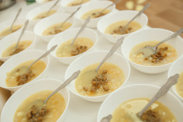 Lunch set (vegetable soup, crackers, plates, spoon) were prepared for children on the long table in the kindergarten