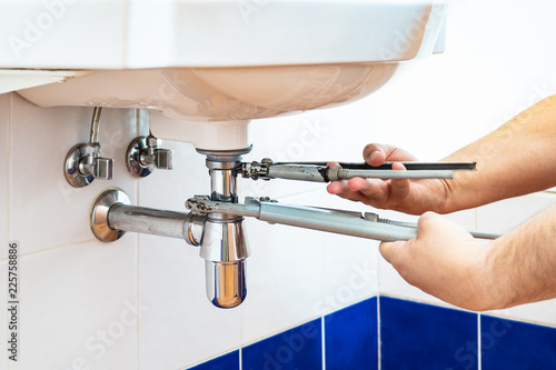 Plumber Unscrews Sink Siphon By Two Pipe Wrenches