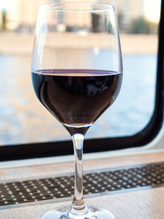 glass of red wine on window sill of cruise boat