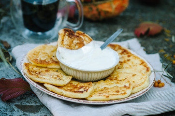 Autumn breakfast with pancakes whith coffee. Cottage cheese pancakes кussian syrniki with sour cream.