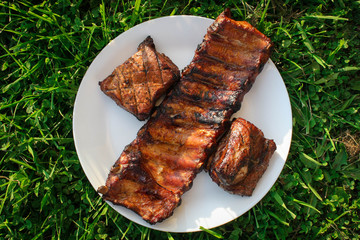 Grilled and smoked pork ribs on a white plate