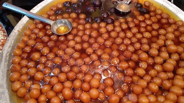 Various fast food stalls in Sarafa area at night in Indore, Madhya Pradesh.  The Indian sweet Gulab jamun.