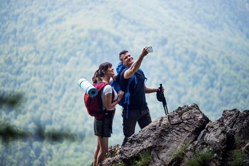 Young Active Couple With Backpack Make Selfie Outdoor At Mountain