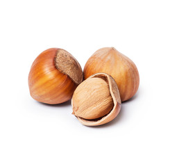 Whole and broken hazelnuts closeup on white background