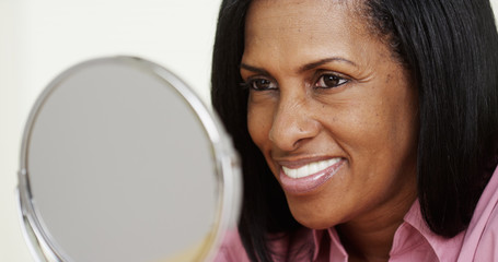 Portrait of African American woman smiling at a mirror