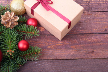 Christmas fir tree with gift box on wooden board