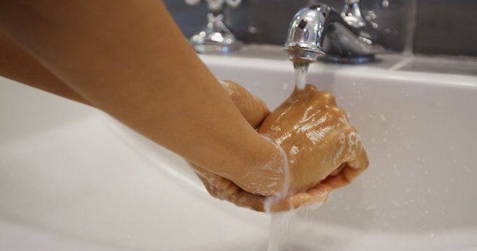 Young pretty black woman washing her hands