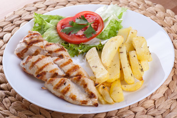 Grilled chicken breast with vegetables and chips 