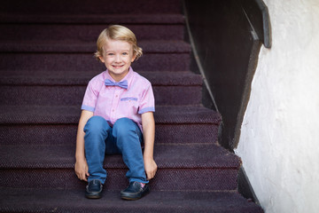 Cute Young Caucasian Boy Portrait Sitting On Stair Steps