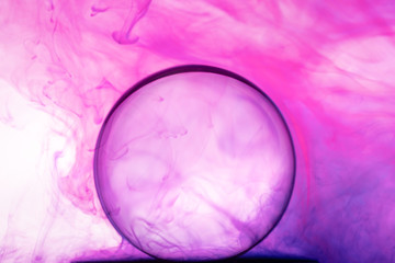 Color Ink flowing in water with Crystal ball on white background.