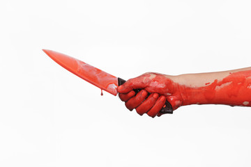 Closeup shot of hand holding a bloody knife with blood dripping.