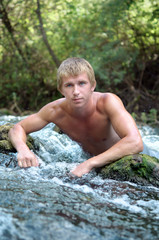 young man swimming in wild Northern river