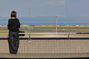 空港で誰かの到着を待つ女性