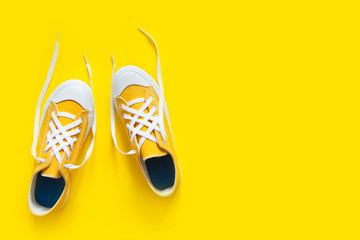 Short low  bright sneakers on a yellow background. © kostikovanata