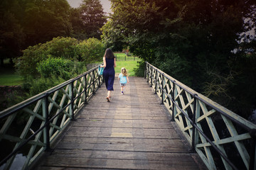 mother and child running across bridge in summer