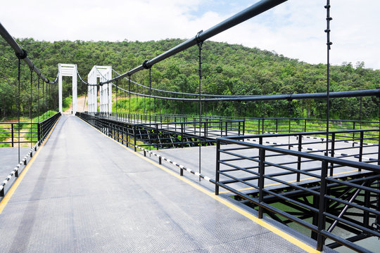 Fototapeta Metal suspension bridge at Mae kuang Udom Thara dam background in Chiang mai,Thailand