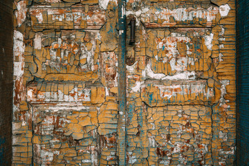 Old wooden door with handle and lock. Many layers of paint in different colors.