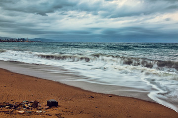 Overcast evening in Barcelona beach, waves and stormy clouds