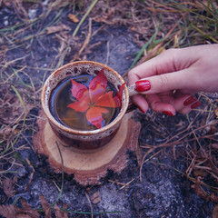 magic potion in ceramic cup and  woman hand in smoke, halloweenmysterious close up