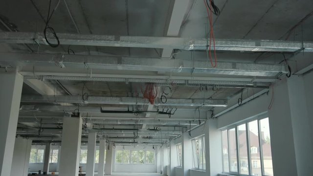 The office is in repair white walls light burning building materials builder building construction contractor engineer industrial male renovation technician development design project slow motion