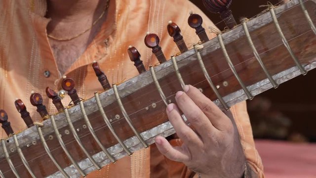 Hands of Indian musician playing Sitar.
