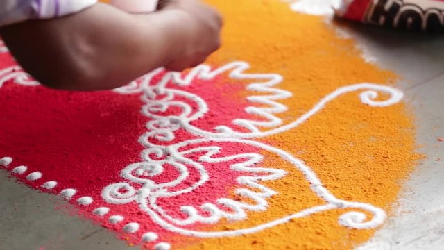 Rangoli with coloured powder being created by Rangoli artist on occasion of Hindu festival, Mumbai, Maharashtra, India.