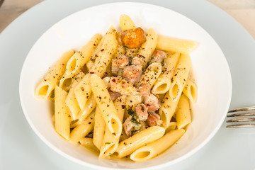 Traditional Italian pasta - penne with pancetta and parmesan cheese close-up