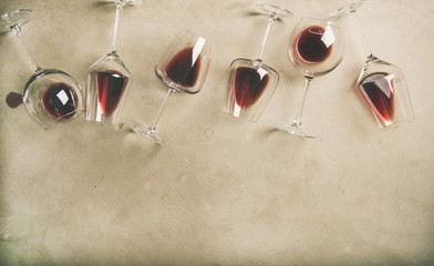 Mise à plat de vin rouge dans des verres sur fond de béton gris, vue de dessus, espace de copie. Bojole nouveau, bar à vin, cave, concept de dégustation de vins