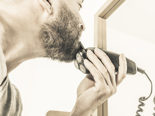 Man shaving trimming his beard