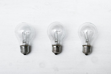 Light bulbs isolated on the white wooden table surface background.