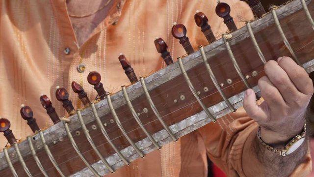 Hands of Indian musician playing Sitar shot in slow motion 180 fps.