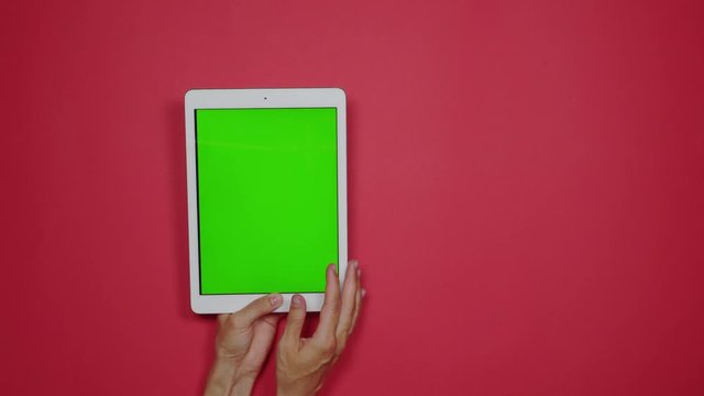 Woman using tablet device with green screen
