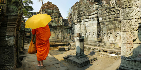 monk with umbrella walking in Angkor wat temple,Cambodia