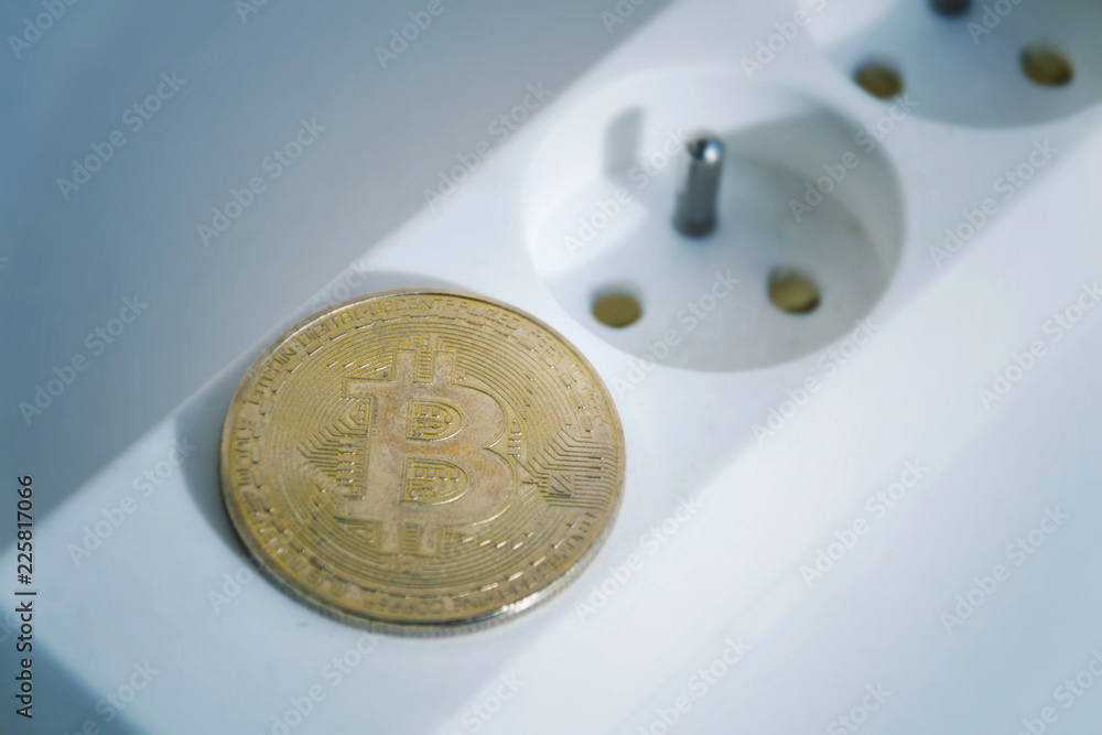 Wall mural bitcoin coin lying on power strip extension cord with two empty sockets, cryptocurrency investing, e
