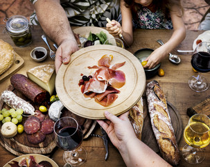 Friends having cold cuts and wine for dinner