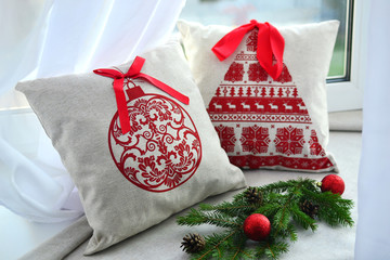 
two scandinavian style Christmas pillows on the window