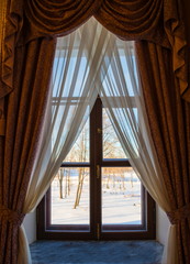 window with beautiful curtains and a winter landscape outside the window