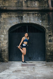 Female athlete warming up legs before running