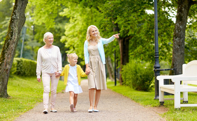 family, generation and people concept - happy smiling mother, daughter and grandmother walking at...