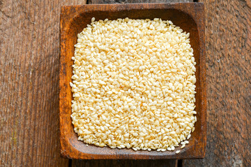 Bright sesame seeds in a wooden dish
