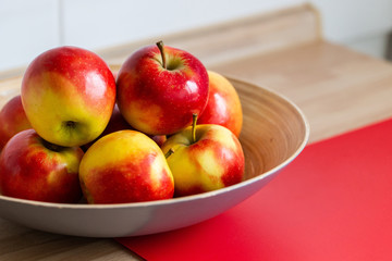 rot gelbe &auml;pfel in einer obstschale und mit einem roten schneidebrett