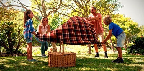 Family spreading the picnic blanket