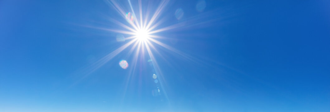 sky background with sun beams on bright blue sky