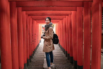 traveler turning back while walking through Torii