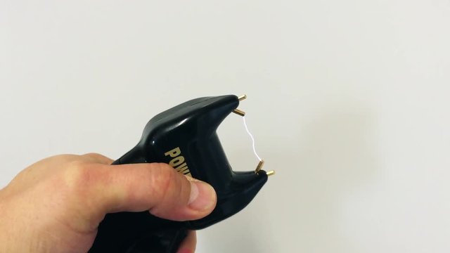 4K Close up of a Stun Gun Waeapon, a man holding a electroshock waepon 