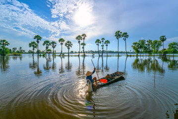 An Giang, Vietnam - September 12, 2018: Unidentified fishers spread a net to catch fish in a lake...