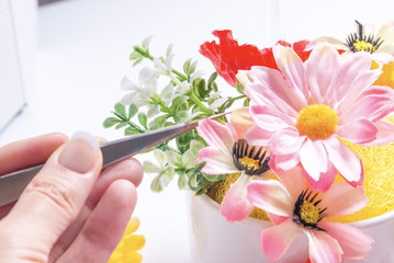 Florist works with decorative artificial flowers.