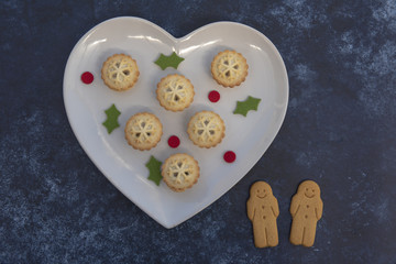 Christmas mince Pies on a heart plate with a dark blue background 