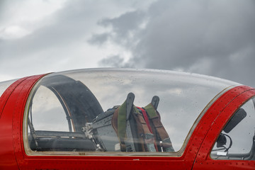 Fototapeta na wymiar Profile of jet plane cockpit against cloudy sky